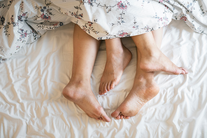 two adults in bed
